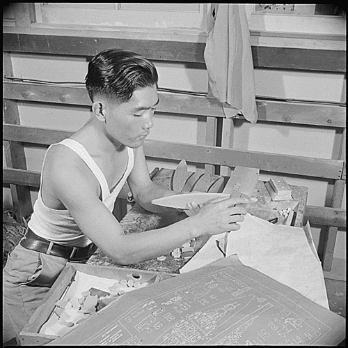 Making hulls for ID model ships
Photograph taken by US Department of the Interior, War Relocation Authority at Gila River Relocation Center, Rivers, Arizona during World War II.

Gila River Relocation Center, Rivers, Arizona. Wataru Ichinotsubo, former produce market employee form Los Angeles, California, is shown sandpapering the hull of a model into final shape in the model ship factory here. These ships are carefully constructed for the Navy by the Japanese-American craftsmen. 
Keywords: ID model ship spotter WW II