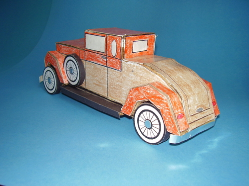 Solid Corrugated model of a 1920's car.
16 profile shaped layers of corrugated cardboard, glued together side by side into a solid body, four layers for each fender.  Car covered with crayon colored paper.
