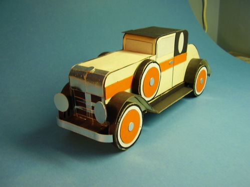 1920's coupe.
16 layers of corrugated cardboard, cut to the car's profile, and glued together side by side to form a solid body.  Sheet cardboard and posterboard fenders, and posterboard for surface covering.
