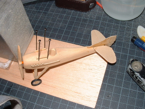 Spad C13
Adding centre section struts made from large dressmaking pins,after setting the pins are cropped and the upper wing offered to them,small holes are drilled and the wing jigged into place.
Keywords: SPAD ,Solid models,carving models in wood,Solid model memories,old time model building,nostalgic model building