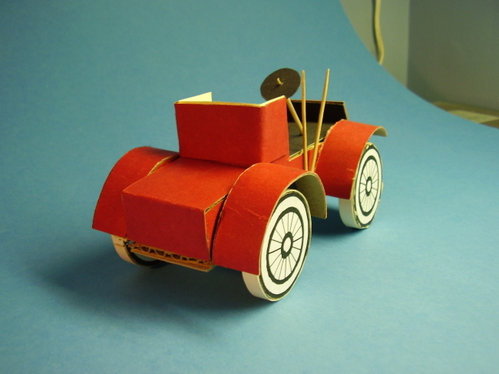 1902 Runabout.
12 layers of corrugated cardboard were cut to the body's profile shape, and glued together side by side to form a solid body.  Sheet cardboard and posterboard fenders; posterboard for surface covering.
